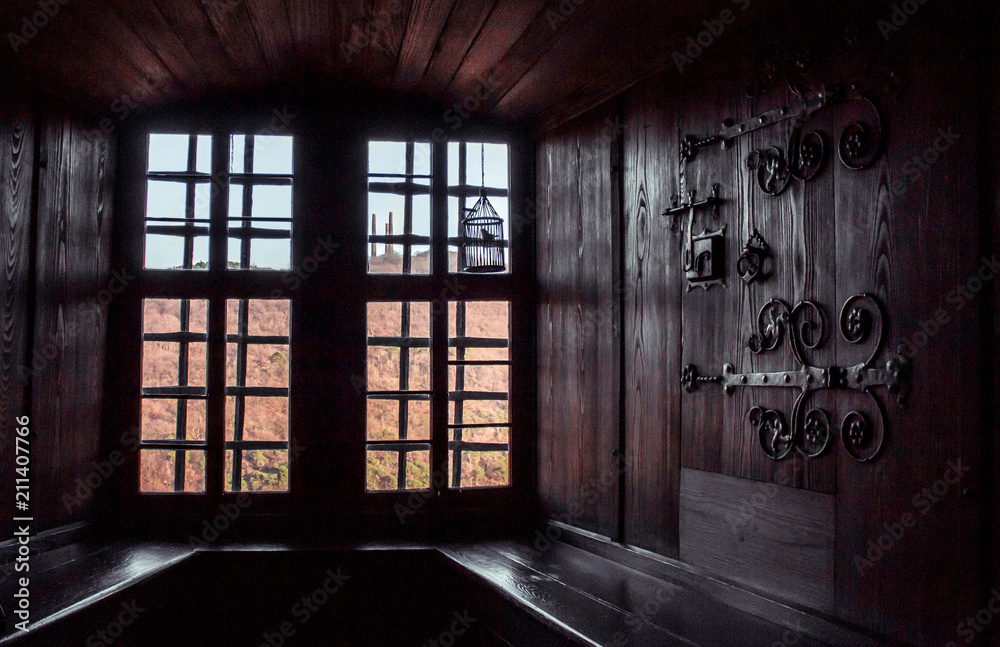 Light from the window in the fortress, view from the room, background of wood and metal