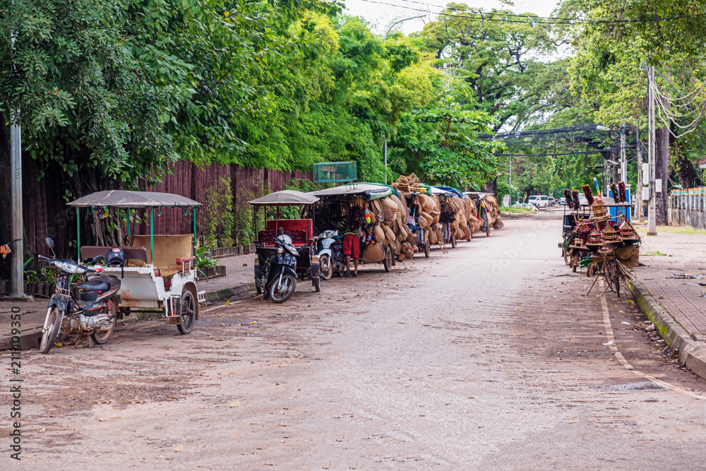 Naklejka premium Motocykle z dołączonymi wózkami na ulicy w Siem Reap w Kambodży.