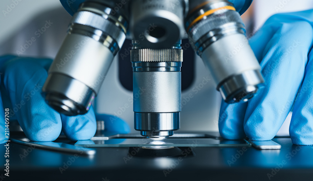 Scientist hands with microscope close-up shot in the laboratory