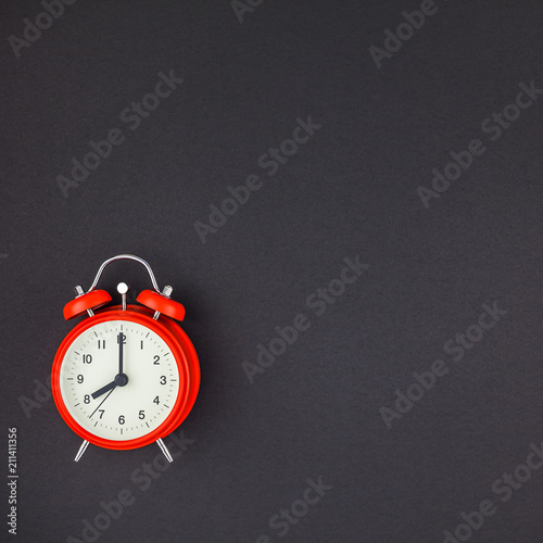 Red vintage alarm clock on dark background