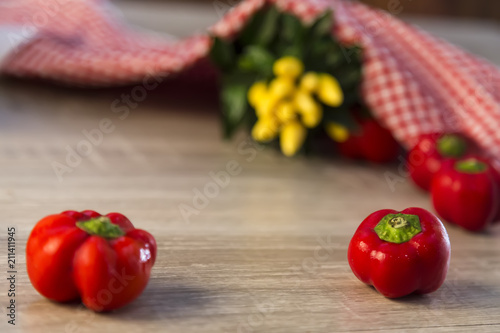organic vegetables red and yellow peppers and red and white cover on the wooden background.
