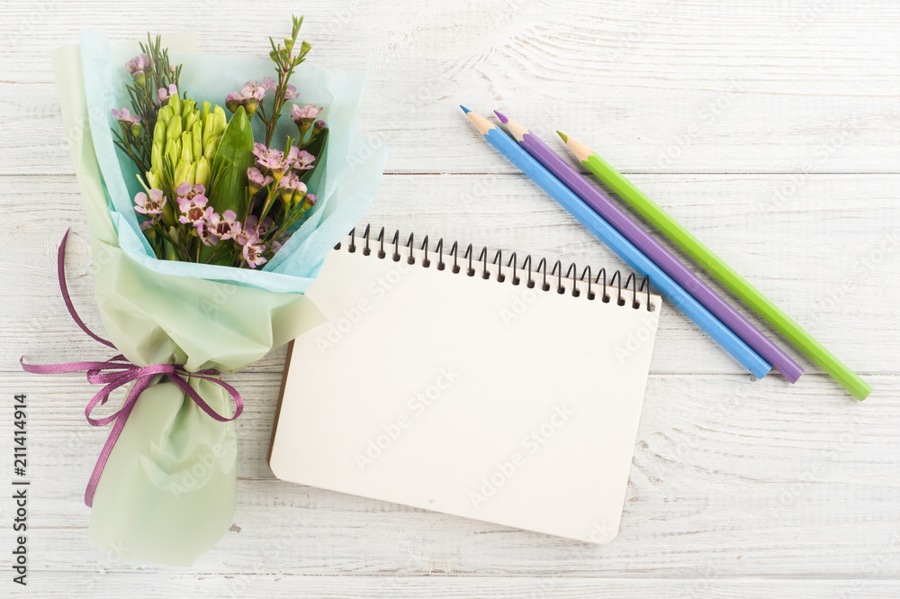 Open empty notebook with bouquet Open empty notebook with bouquet