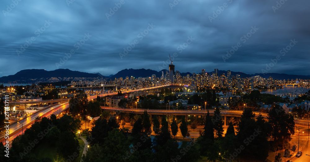 Aerial panoramic view of Downtown City during a cloudy night after sunset. Taken in Vancouver, BC, Canada.