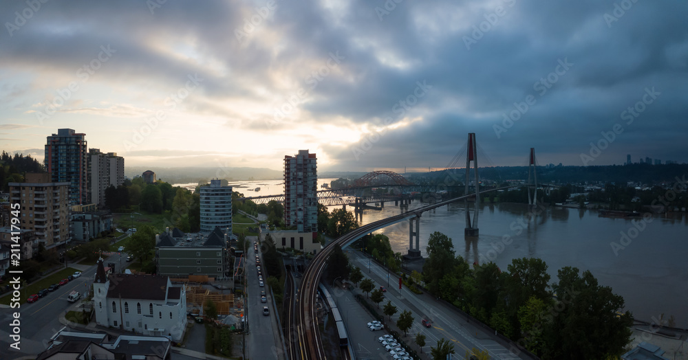 Fototapeta premium Aerial Panoramic view of Fraser River and Bridges during a vibrant sunrise. Taken in New Westminster, Greater Vancouver, British Columbia, Canada.