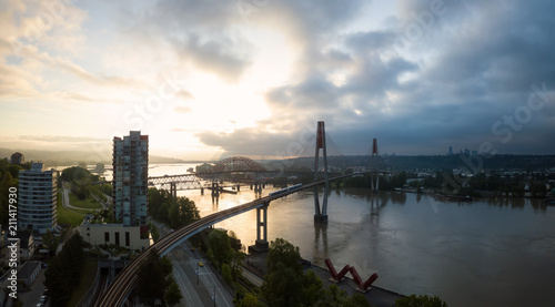 Aerial Panoramic view of Fraser River and Bridges during a vibrant sunrise. Taken in New Westminster  Greater Vancouver  British Columbia  Canada.