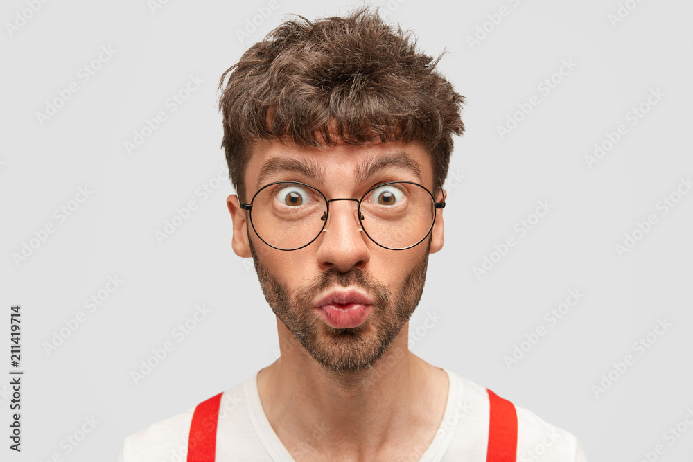 Headshot Of Handsome Surprised Male With Stunned Expression Rounds Lips And Opens Eyes Widely Can T Believe In Latest Sudden News Poses Against White Background People And Facial Expressions Stock Photo Adobe