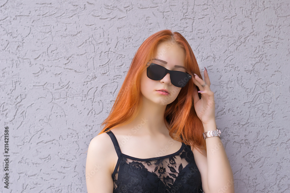 Beautiful young red hair woman in sunglasses on textured background Beautiful young red hair woman in sunglasses on textured background