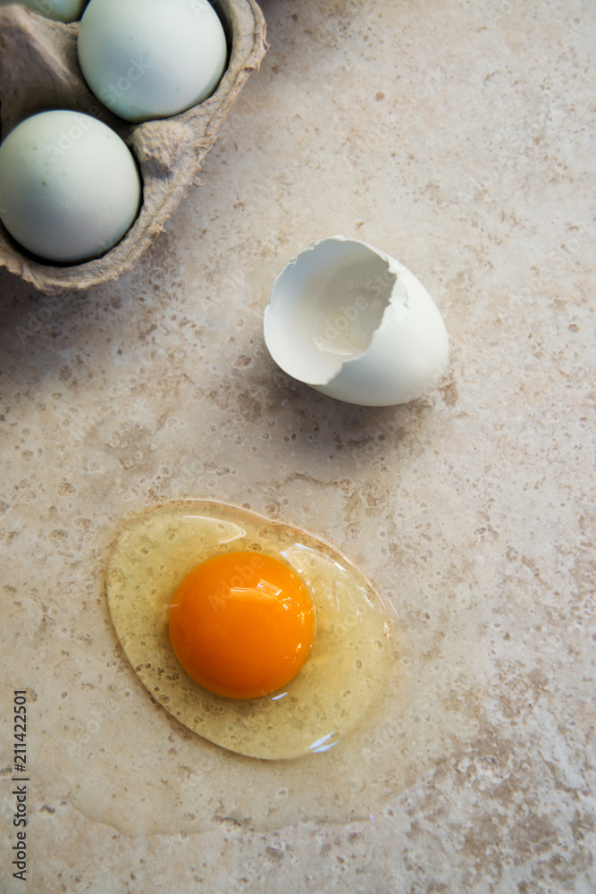 Organic Egg is Being Broken on Smooth Countertop Organic Egg is Being Broken on Smooth Countertop