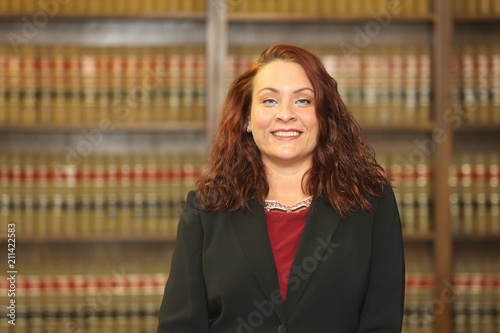 Portrait of an attractive redhead woman, woman lawyer in law library