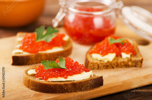 Red salmon caviar in sandwich and bowls