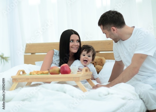 Family having nutritive breakfast in bed in the morning