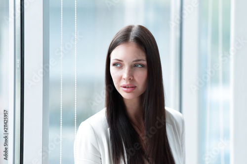 closeup.young business woman standing near the window in the office