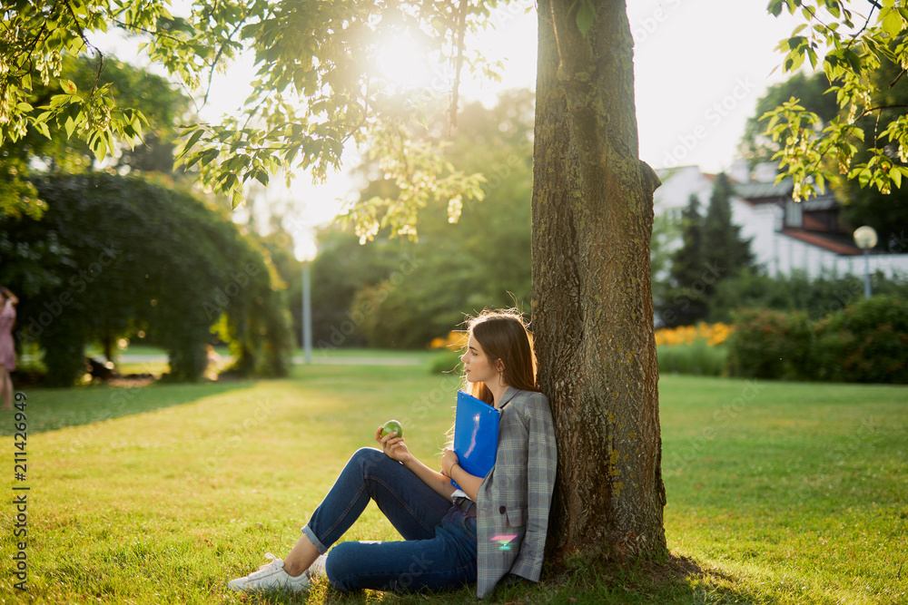 Pretty girl with her book in park background, sunset Pretty girl with her book in park background, sunset