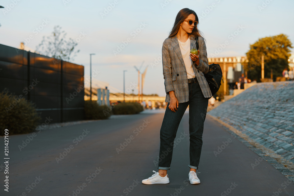 Fashion girl walk on the street with sunset background