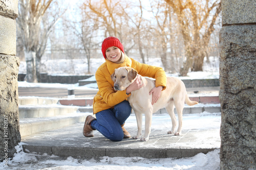 Woman hugging cute dog outd...