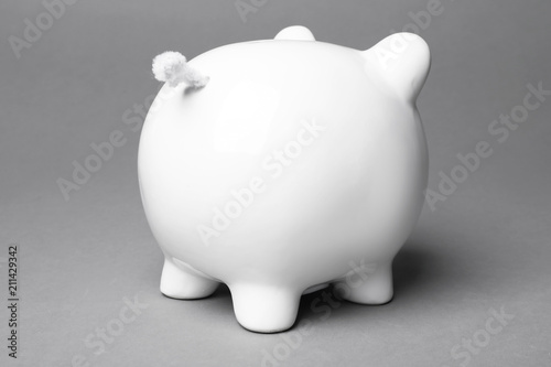 Cute white piggy bank on gray background