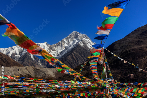Mount Gongga (also known as Minya Konka) - Gongga Shan in Sichuan Province, China. Tibetan Prayer Flags with Sacred Snow Mountain in the background. Himalayas, Highest Mountain in Sichuan Province photo