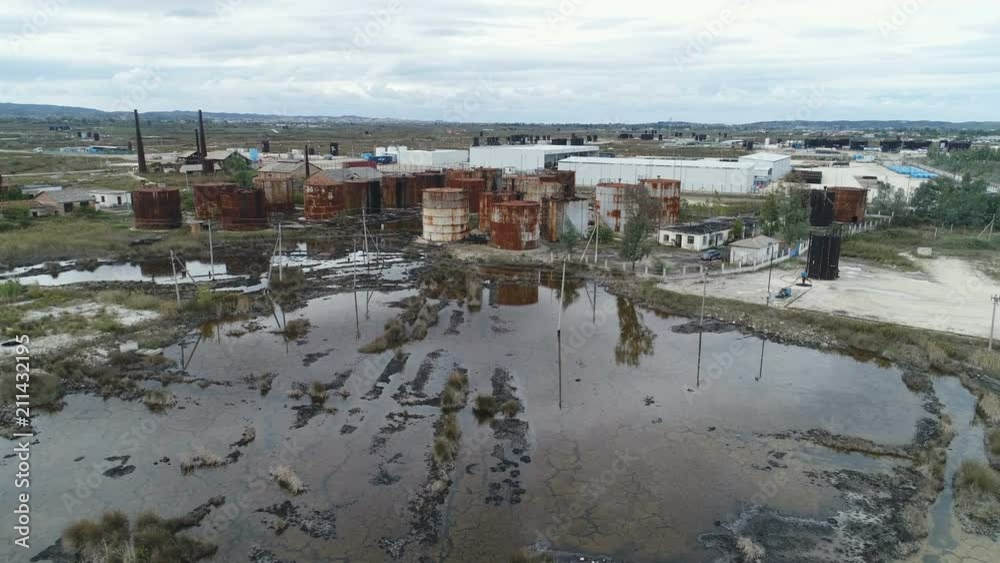 Slow drone flight over leaking tanks, spilling crude oil on vegetation in Albania, Southeastern Europe Slow drone flight over leaking tanks, spilling crude oil on vegetation in Albania, Southeastern Europe