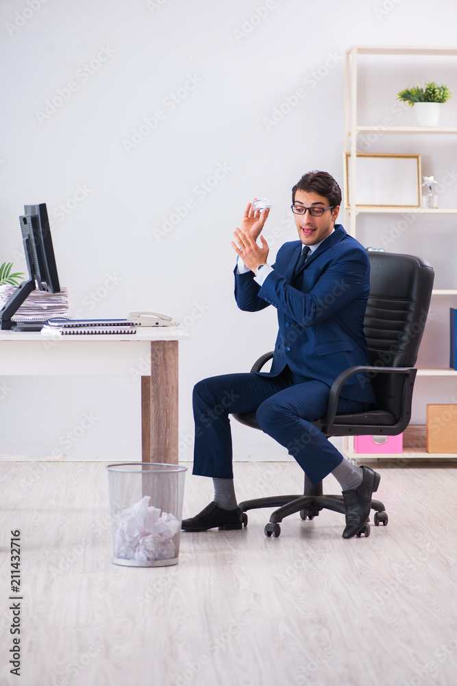 Young handsome businessman employee working in office in paperwo Young handsome businessman employee working in office in paperwo