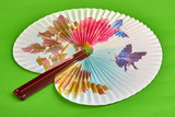 Closeup of Traditional Chinese paper fan on green background.Hand paper fan