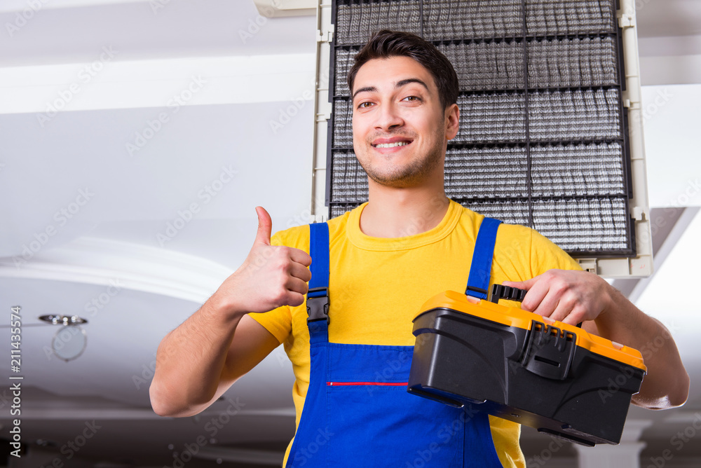 Repairman repairing ceiling air conditioning unit Repairman repairing ceiling air conditioning unit