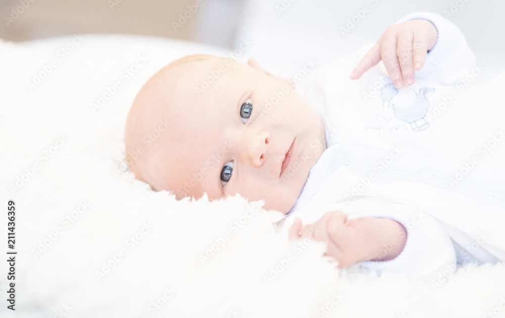 Awake Newborn with Eyes Open in Comfortable Sleeper Pajamas on a White Soft Blanket Awake Newborn with Eyes Open in Comfortable Sleeper Pajamas on a White Soft Blanket