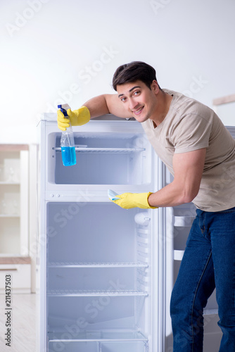 Man cleaning fridge in hygiene concept