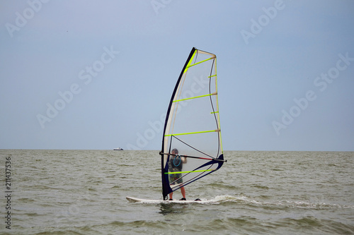 One windsurfer in the sea on a cloudy day. Selective focus, copy space.