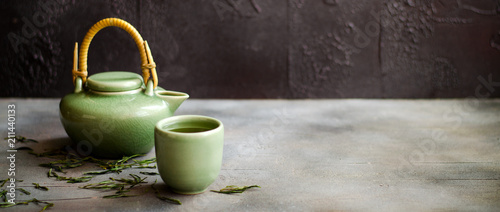 Chinese green tea in teapot on dark background