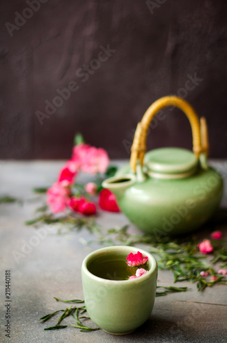 Chinese green tea with roses on dark background