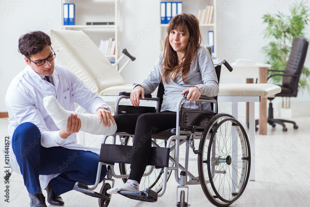 Male doctor examining female patient on wheelchair Male doctor examining female patient on wheelchair