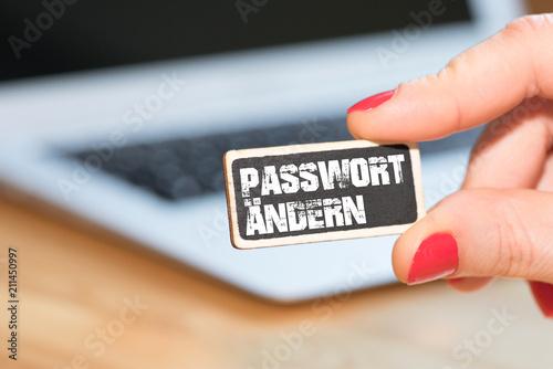 Eine Frau, ein Computer und ein Schild Passwort Ändern