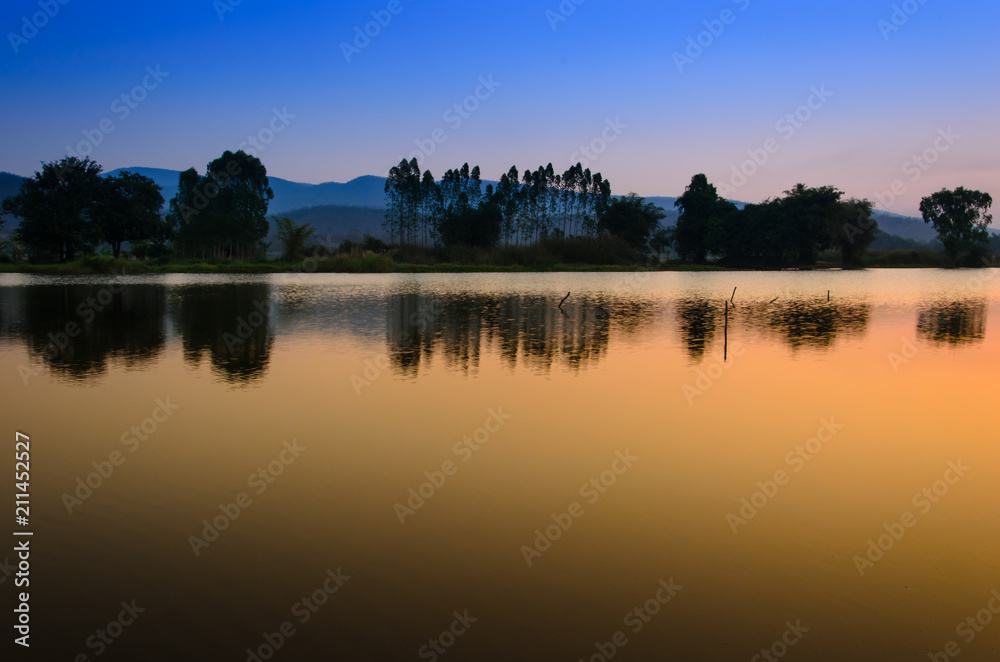 Twilight sky with mountain landscape view reflects on water