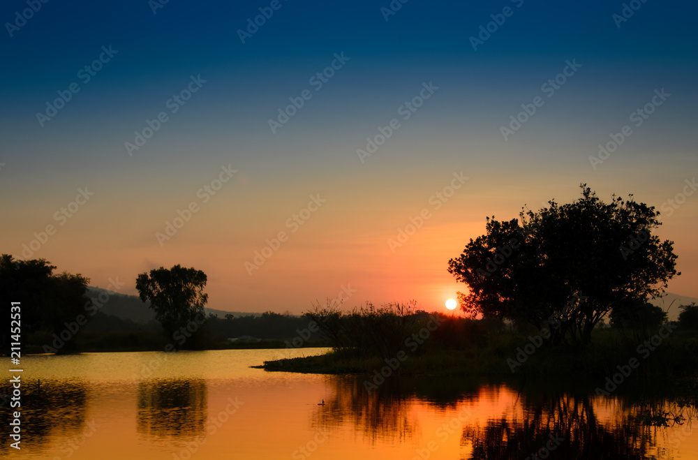 Twilight sky with mountain landscape view reflects on water