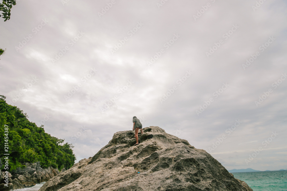 Man standing on the edge of the cliff in an deserted island.