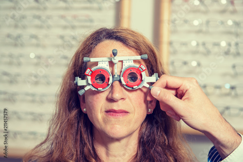  optican checking eyes of woman for new glasses