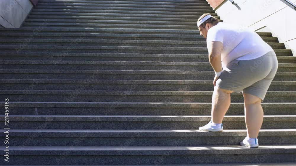 Obese man climbing stairs, overweight causes pain in joints, varicose veins