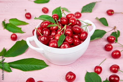 Red cherry in white bowl