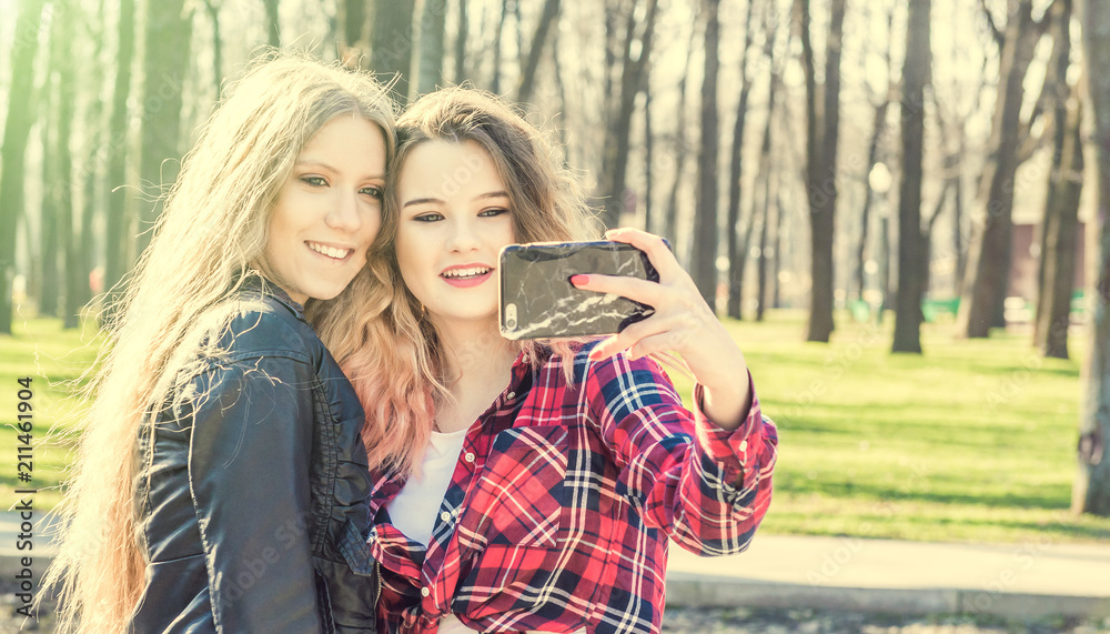 Happy girl friends taking a selfie on a summer day Happy girl friends taking a selfie on a summer day