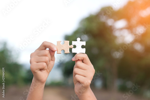 Little child hands holding piece of blank jigsaw puzzle