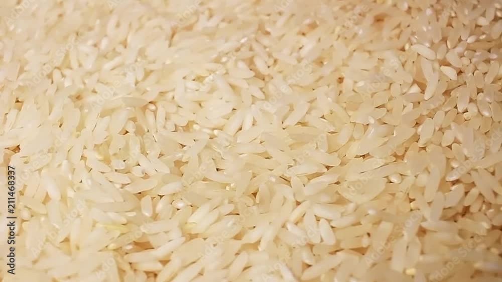 Raw rice grains rotating pattern macro texture background backdrop footage video. Raw rice grains rotating pattern macro texture background backdrop footage video.