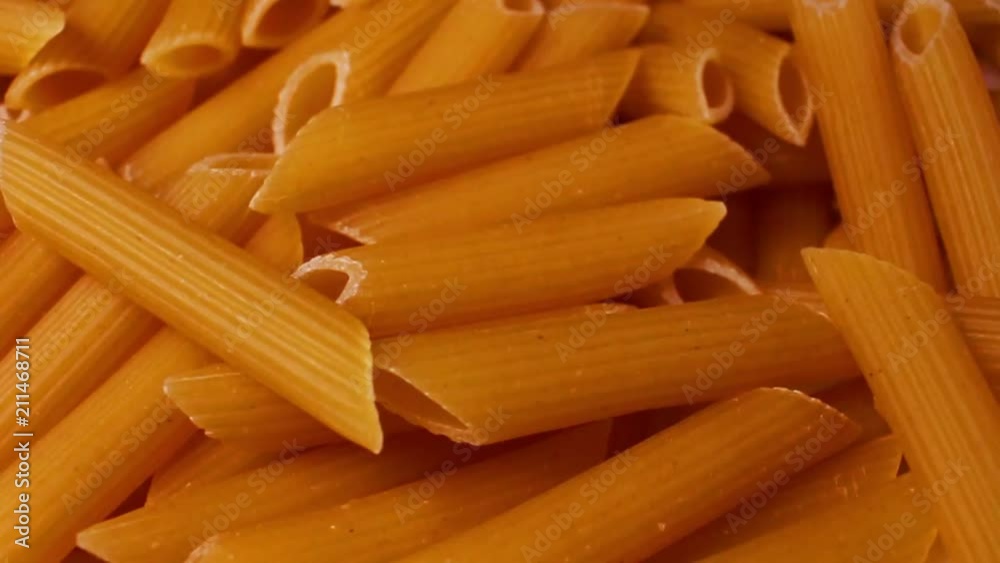 Whole grain pasta penne rotating pattern macro texture background backdrop footage video. Whole grain pasta penne rotating pattern macro texture background backdrop footage video.