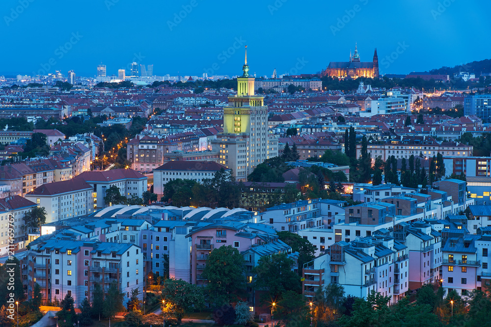 Landscape or cityscape Picture of Prague, during the sunset or in blue hour shows contrast between communist style hotel building and Saint Vitus cathedral.  