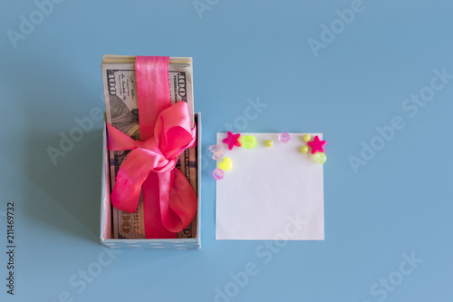 U.S. dollars banknotes laying in bow decorated gift box. Opened gift and dollars. Gift box with banknote of dollar.. Place for your text. Place for congratulations