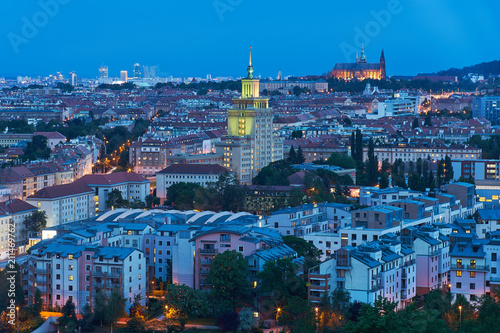 Landscape or cityscape Picture of Prague, during the sunset or in blue hour shows contrast between communist style hotel building and Saint Vitus cathedral. 