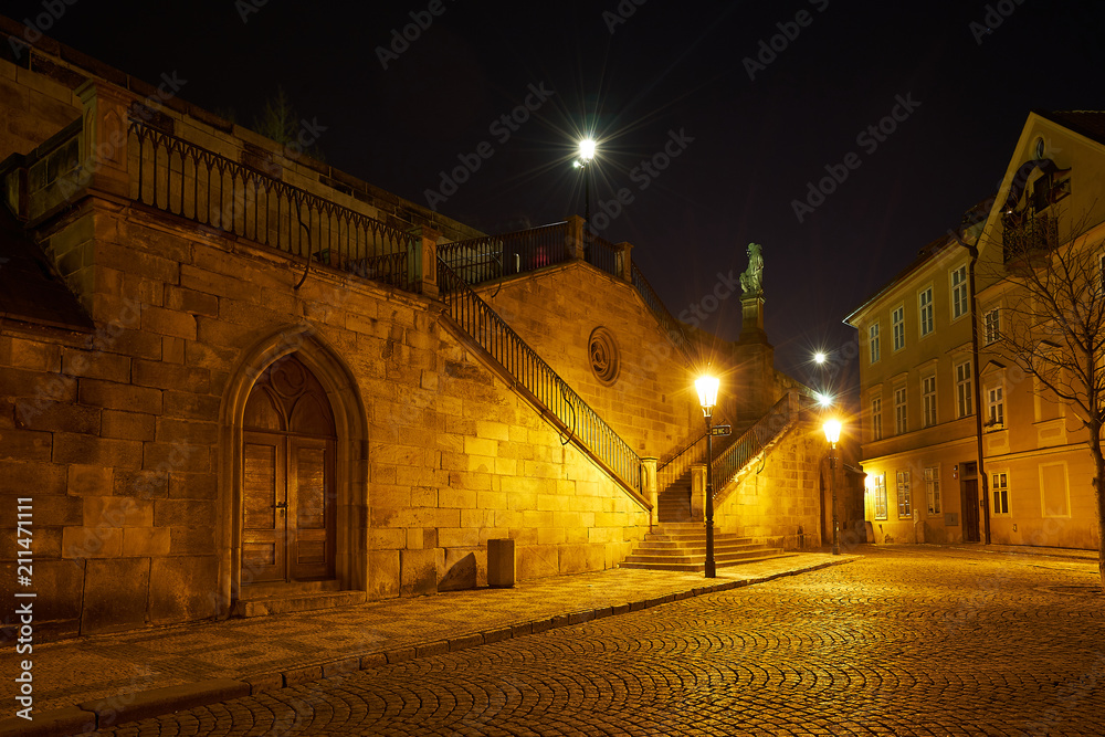 Wall Mural Night Picture of the historical gotic style architecture in the downtown of Prague, capitol of Czech republic, shown first arch of epic and famous Charles bridge