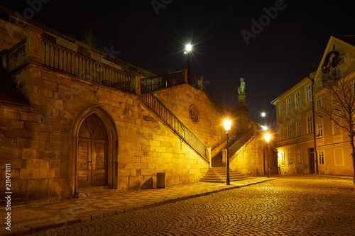 Night Picture of the historical gotic style architecture in the downtown of Prague, capitol of Czech republic, shown first arch of epic and famous Charles bridge.