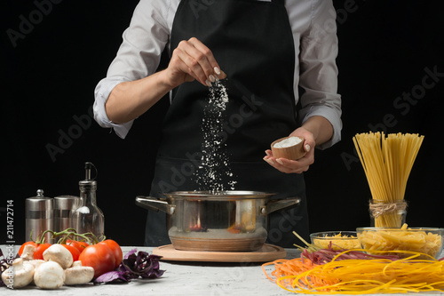 Canvastavla The chef prepares spaghetti and pasta, salt water, against a dark background, th