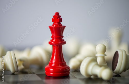 Red chess between black chess board game for competition and strategy, business success concept