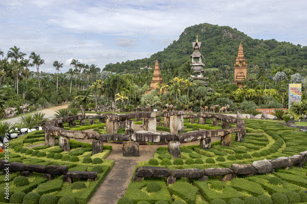 Tropical garden Nong Nooch garden in Thailand Pattaya on a background of mountains with trees, blue sky with clouds.